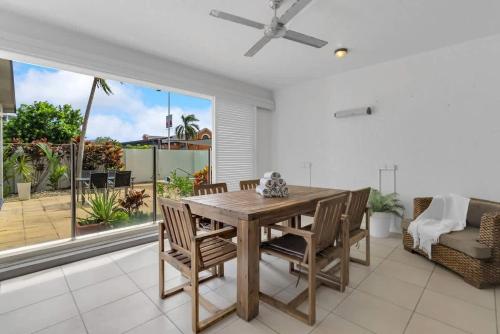 a dining room with a wooden table and chairs at 'Eclipse' A Poolside Family Escape in the CBD in Cairns