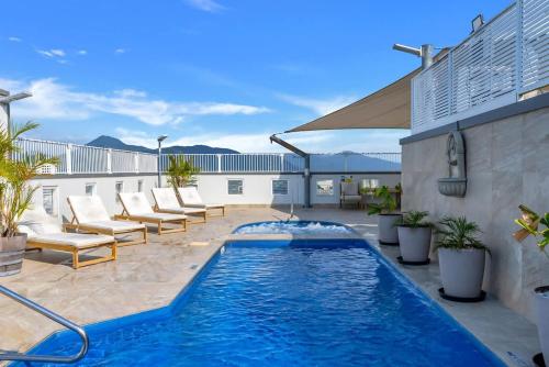 a swimming pool on a patio with chairs and a building at McLeod Nook - Poolside Studio by Waterfront & Market in Cairns