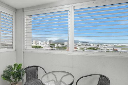 two chairs and a table in front of a window at 'Seaside Azul' A Central Studio with Rooftop Pool in Cairns