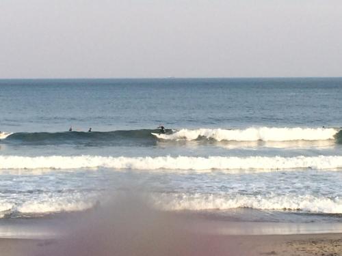 a group of people riding waves in the ocean at Traveler's Wharf Shichigahama in Shichigahama