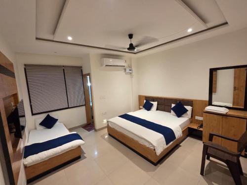 a bedroom with two beds and a desk in it at Vrind Orchid- Near Prem Mandir in Vrindāvan