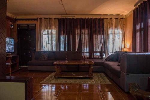 ein Wohnzimmer mit einem Sofa und einem Couchtisch in der Unterkunft Maison Belle Vue in Le Morne