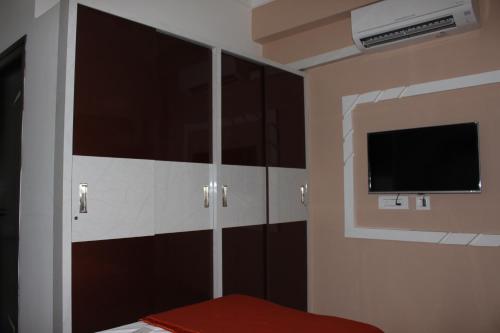 a bedroom with black cabinets and a flat screen tv at Mahas Inn in Hyderabad