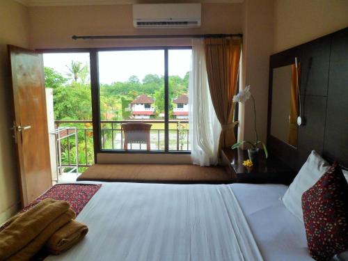 Un dormitorio con una cama con vista a un balcón. en Nuriani Rooms, en Ubud