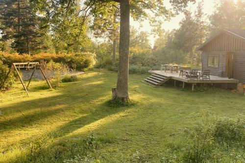 a backyard with a picnic table and a cabin at Nature And Veranda In Perfect Alignment in Djurhamn