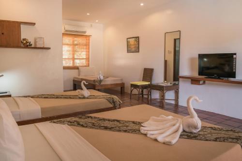 ein Hotelzimmer mit zwei Schwänen auf dem Boden in der Unterkunft Acacia Tree Garden Hotel in Puerto Princesa