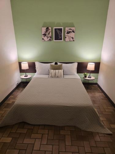 a bedroom with a large bed with two lamps at Luca in San José