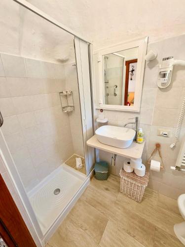 a white bathroom with a sink and a shower at Trulli Fenice in Martina Franca