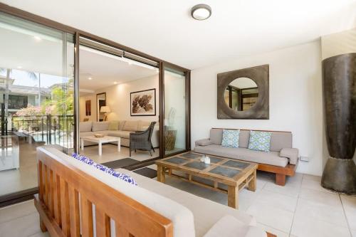 a living room with a couch and a table at Poolside Relaxation - Resort Retreat with Beach Access in Port Douglas