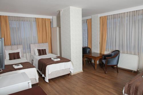 a hotel room with two beds and a desk at Çamlıca Tower Hotel in Istanbul