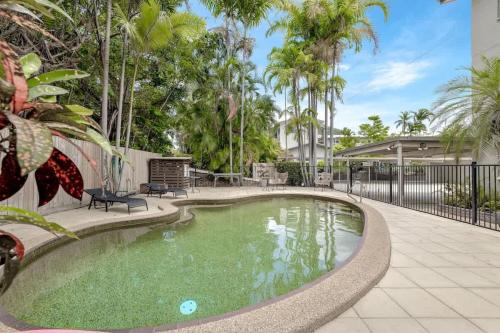 a swimming pool in a yard with palm trees at The Tropical Trinity - A Breezy Beachside Getaway in Trinity Beach