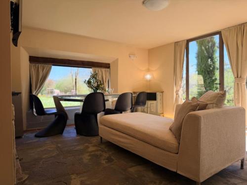 a bedroom with a couch and chairs and a large window at Borgo Spescia Pool Park and Relaxation in Camposonaldo