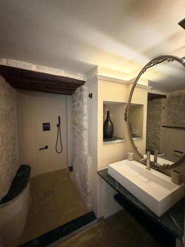 a bathroom with a sink and a tub and a mirror at Borgo Spescia Pool Park and Relaxation in Camposonaldo