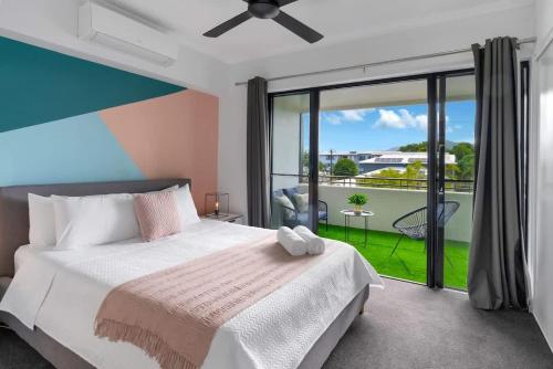 a bedroom with a bed and a balcony at The Loft - Trendy Coastal Charm with Pool in Cairns