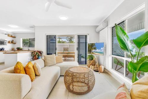 a living room with a couch and a table at The Bird House - Poolside Haven a Stroll from Beach in Palm Cove