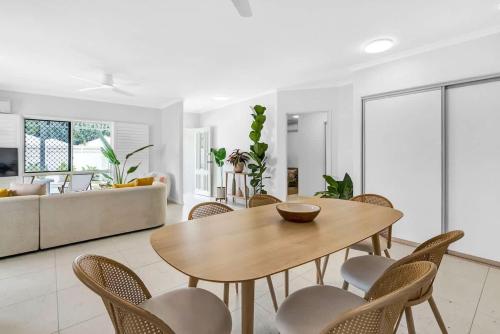a living room with a wooden table and chairs at The Bird House - Poolside Haven a Stroll from Beach in Palm Cove