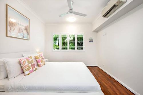 a white room with a bed and a window at Trinity Beach Bliss - Experience Tropical Living in Trinity Beach