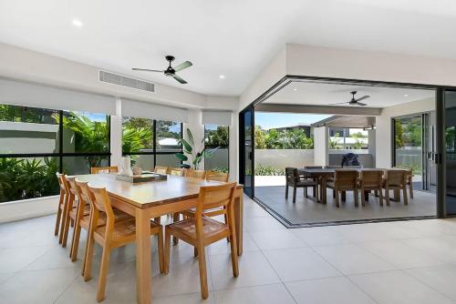 a dining room with a wooden table and chairs at The Elysian at Argentea - Beachside Stay with Pool in Palm Cove
