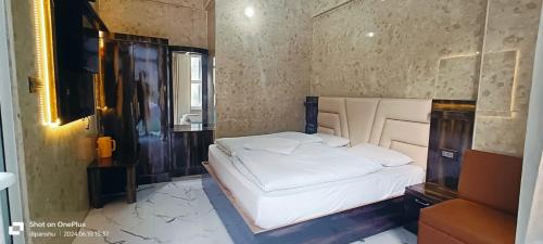 a bedroom with a white bed and a mirror at Hotel Mansarovar in Pāndukeshwar
