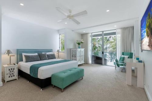 a bedroom with a bed and a table and chairs at Bougainvillea - Beachside Luxury at The Drift in Palm Cove