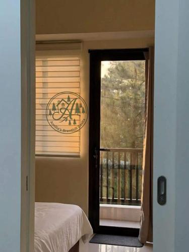 a bedroom with a door open to a balcony at Unit 208 Venus Transients-Brenthill in Baguio
