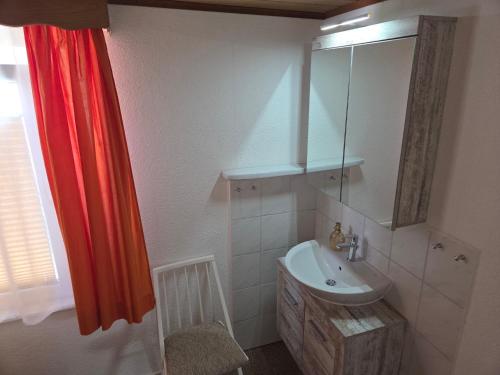 a bathroom with a sink and a red shower curtain at Ferienhaus Olbersdorf in Olbersdorf