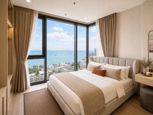 a bedroom with a large bed with large windows at The Edge central pattaya in Pattaya