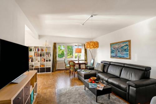 a living room with a couch and a tv at Ca' Lidia - Lugano Villa with Garden and Parking - Happy Rentals in Pregassona