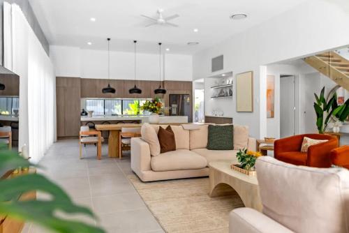 a living room with a couch and a table at Salt - Beachfront Luxe with Private Pool in Palm Cove