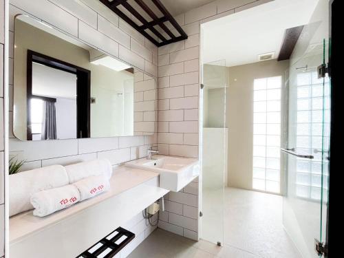 ein Badezimmer mit Waschbecken und Spiegel in der Unterkunft Coco Hotel in Bangkok