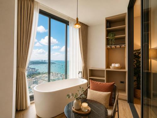 a bathroom with a tub and a large window at The Edge central pattaya in Pattaya