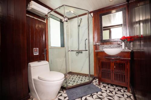 a bathroom with a toilet and a shower and a sink at Sunlight Legend Cruise in Ha Long