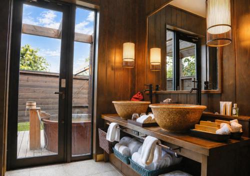 a bathroom with two sinks and a large mirror at エンゼルグランヴィラ由布院 in Yufu