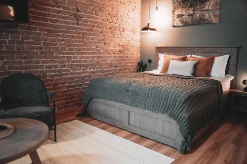 a bedroom with a bed and a brick wall at Apartment No 14 in Līgatne
