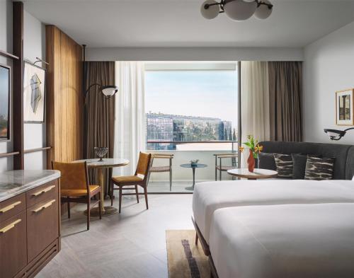 a hotel room with a bed and a view of a city at Conrad Athens The Ilisian in Athens