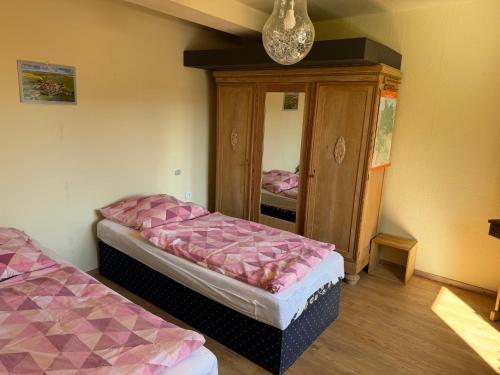 a room with two beds and a cabinet with a mirror at Himmelswege in Nebra