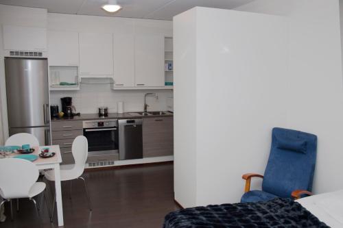 a kitchen with white cabinets and a table and chairs at Kotiyksiö Center in Lahti