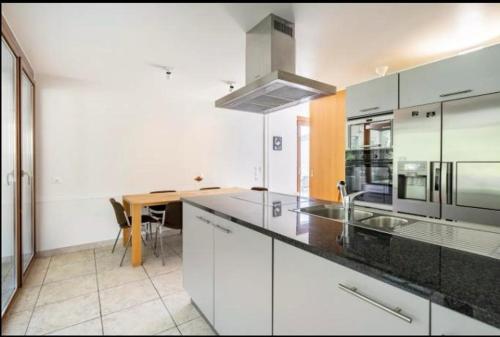 a kitchen with white cabinets and a counter top at Hop zanzibar 1 in Belmont-sur-Lausanne