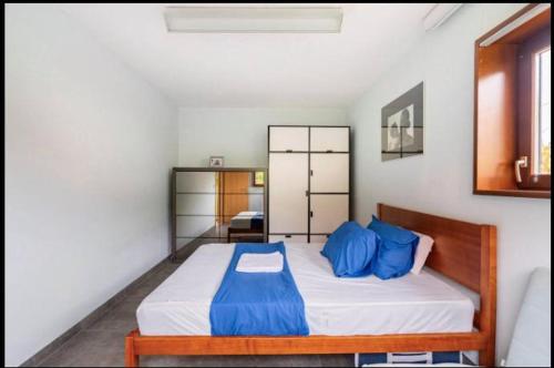 a bedroom with a large bed with blue pillows at Hop zanzibar 1 in Belmont-sur-Lausanne