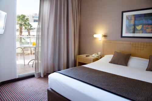 a hotel room with a bed and a balcony at Royal Garden by Isrotel Collection in Eilat
