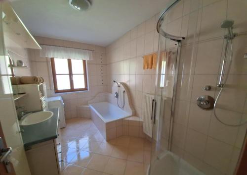 a bathroom with a shower and a tub and a sink at Privatzimmer am Weinbrunnen in Vorchdorf