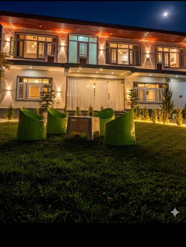 a house with a lawn in front of it at night at The Meer Mansion in Srinagar