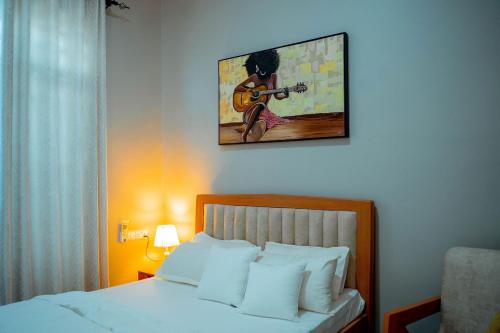 a bedroom with a bed with a guitar on the wall at Ligas homes in Dodoma