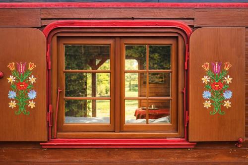a window on the side of a house with flowers at Relais Équestre du Neufeld - Roulotte Nature in Oberhaslach