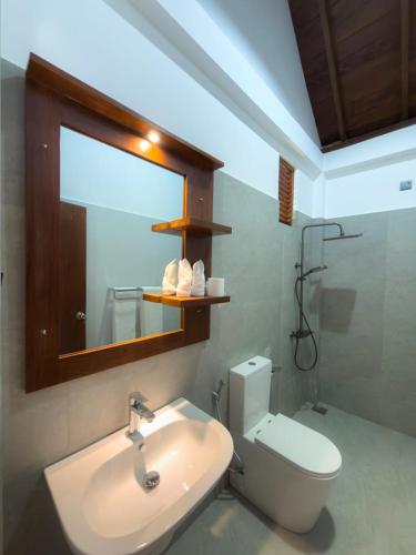 a bathroom with a sink and a toilet and a mirror at Moonstone herbal villa in Balapitiya
