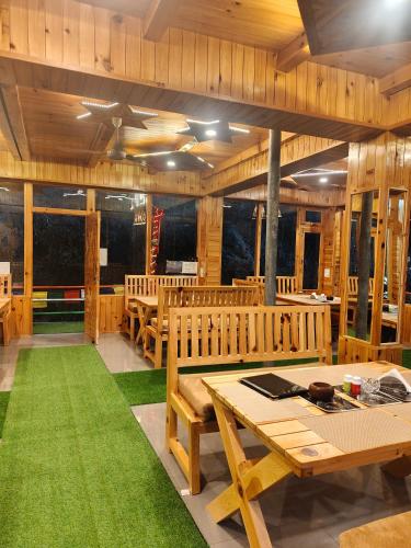 a dining room with wooden tables and green carpet at sanoview in Kulu