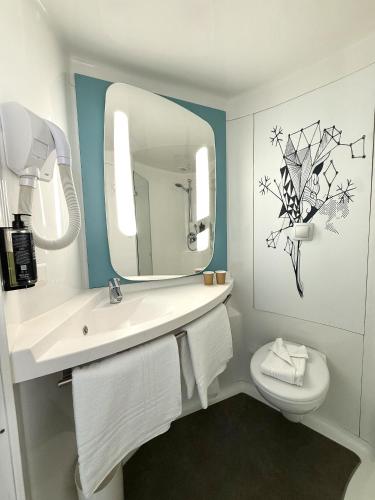 a bathroom with a sink and a mirror and a toilet at Ibis budget Dijon Centre Clemenceau in Dijon