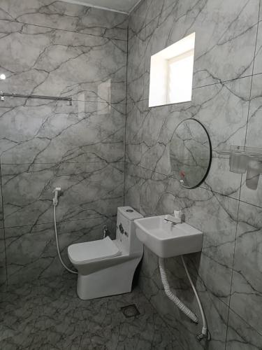 a bathroom with a toilet and a sink at Ronazio Beach View Residency in Auroville
