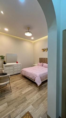 a bedroom with a bed and a table and a chair at استراحه بيت الزلفى in Fulūj Sayghah