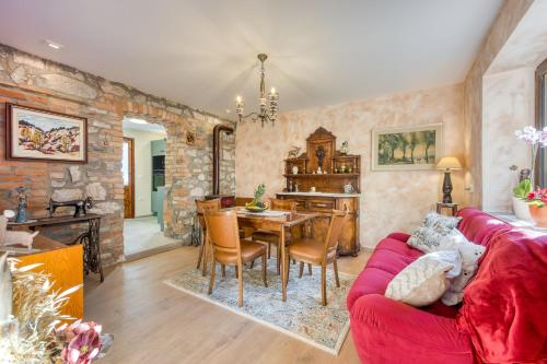 a living room with a red couch and a table at Vila Leonarda with Terrace and Garden - Happy Rentals in Miren